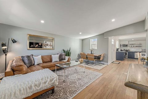 - Spacious open concept layout features a cozy sectional, dining table for four, & layered rugs
- Soft gray walls and light wood floors create a calm and cohesive backdrop
- Plenty of natural light makes this space perfect for relaxing or gathering