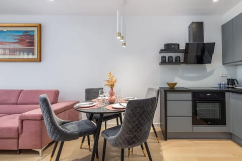 A dining area connected to the kitchen, featuring a modern table setup with flowers and candles.
