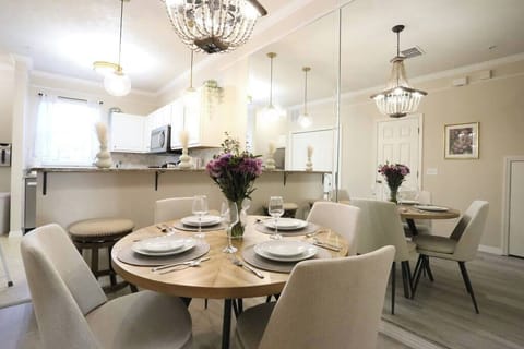 Our open-concept dining room features a gorgeous beaded chandelier, mirrored accents for a spacious feel, and comfortable upholstered seating. It's the ideal spot to enjoy a home-cooked meal while staying connected to the kitchen and living areas.