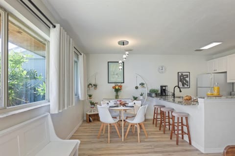 Enjoy breakfast by the window at our modern dining table, surrounded by lush greenery and natural light.