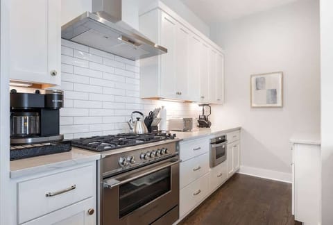 Cook, entertain, and enjoy in a modern white kitchen with stainless appliances.