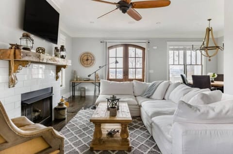 - Bright living room with cozy white sectional and warm rustic décor   - Fireplace TV and wooden accents create a welcoming inviting vibe   - Perfect gathering space for relaxing conversation and comfort