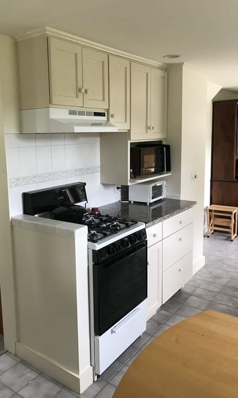 Kitchen with gas stove/oven, microwave and toaster.