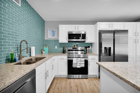 Modern fully equipped kitchen with minimalist design, stainless steel appliances