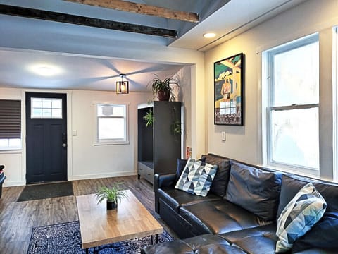 Open concept living room with rustic, exposed beams that showcase the upper half story loft space.