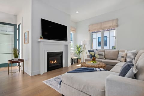 Fireplace anchors the living room surrounded by bright windows