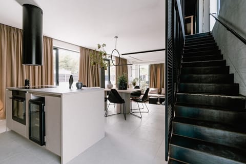 Modern air conditioned interior of the bright ground floor with fully equipped kitchen, a dining area and internal staircase in the new pet friendly summer home villa Noir Vodice 