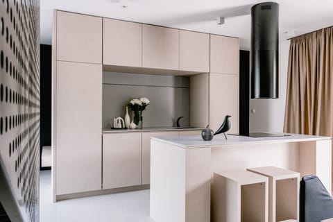 Sleek minimalistic design of the fully equipped kitchen with a kitchen island with chairs, in vitro ceramic stove and elegant cylindric kitchen hood in the new Vodice vacation rental for 8