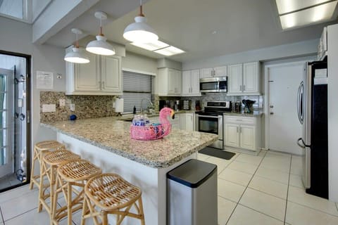 The FULLY STOCKED kitchen features even more bar-top seating and plenty of space to whip up an amazing home-cooked meal of your own.