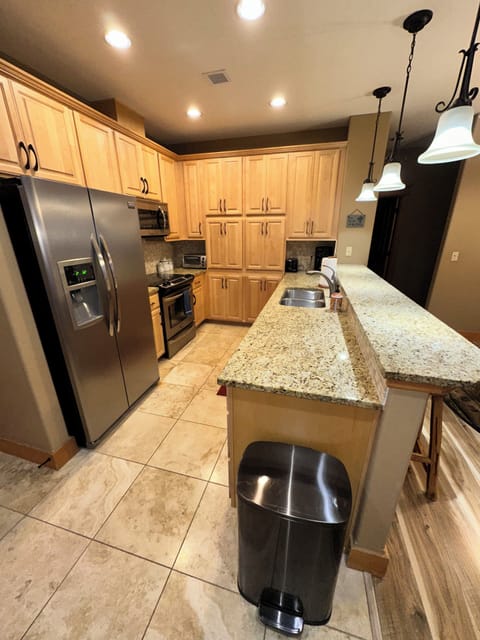 Fully stocked kitchen with stainless steel appliances.