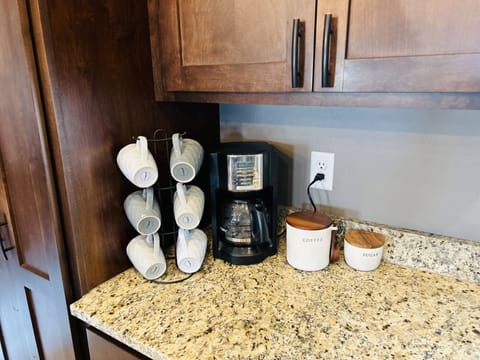 Extra coffee cups, glasses, plates, bowls are in the cupboard above.