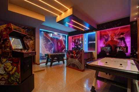 Superhero-themed arcade room with games and neon lights—fun for all ages!