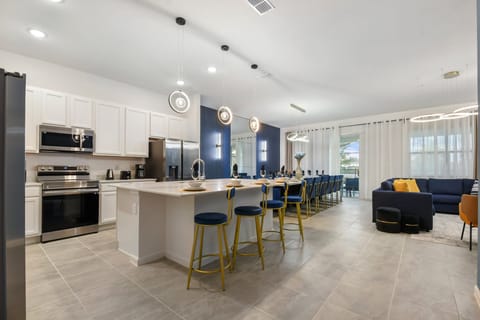 Modern kitchen with sleek appliances, island seating, and open layout—cook and connect!