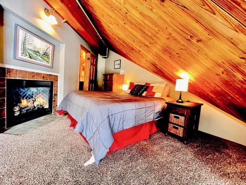 Spacious bedroom with a vaulted ceiling and rustic wood accents.