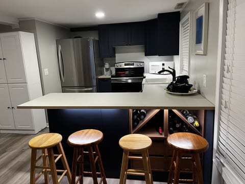 Kitchen breakfast bar view. White cabinet (left) has bath/beach towels, etc.