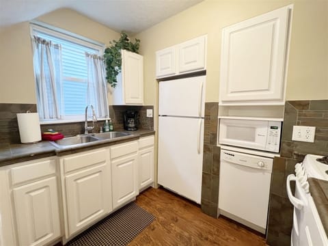 Fully equipped kitchen with dishwasher, full size refrigerator, and apartment size range