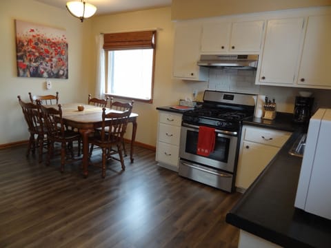 Kitchen with full stove and refrigerator and stocked with more essentials 