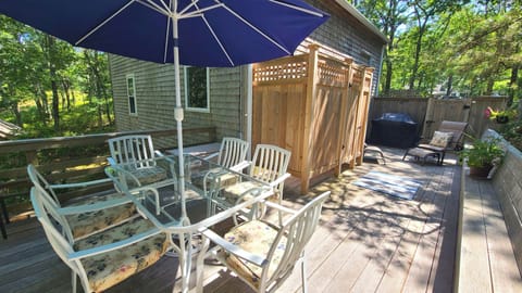 Wonderful deck with enclosed outdoor shower has a dining table and gas grill
