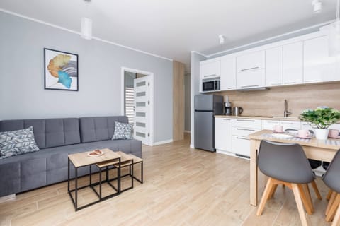 A cozy living room with a sofa, table, and bright, minimalist decor.
