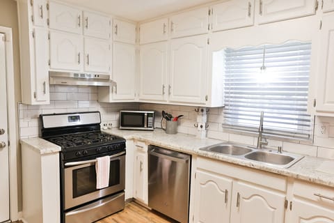 Lots of bright white cabinets in the kitchen with stainless steel appliances