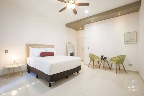 A plush queen bed and a nightstand with a lamp for reading