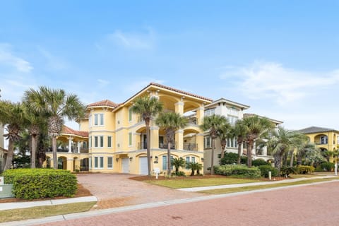 Stunning Mediterranean-style villa with palm trees and elegant architecture in an upscale coastal neighborhood.