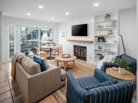 This warm, cozy living space offers direct access to an outdoor lounge area, complete with comfortable lounge amenities.