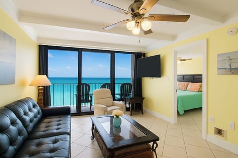 Living Room with A Great View. It Has A Queen Size Leather Sleeper Sofa, 2 Swivel/Rocker Recliners, 3 End Tables, A Coffee Table, A 58" Wall Mounted Smart TV And Balcony Access