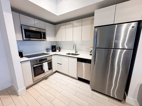 Fully equipped kitchen with stainless steel appliances and a stylish backsplash.