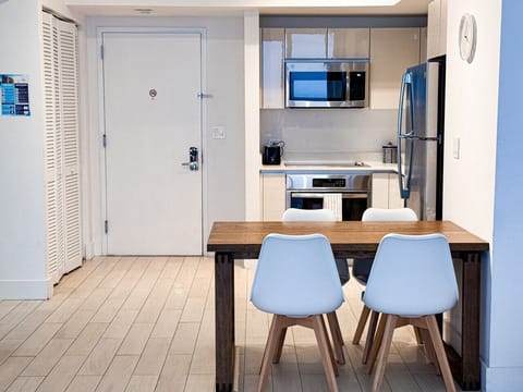 Modern dining area connected to a fully equipped kitchen.