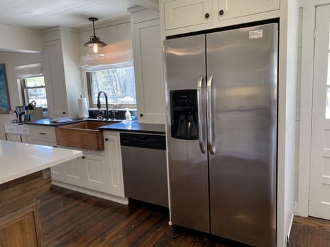 Refrigerator with ice maker, copper sink, and dishwasher. 