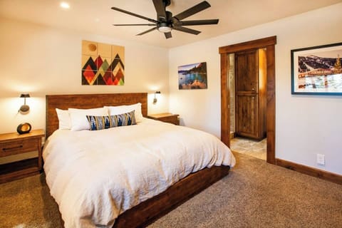 Downstairs Master Bedroom with king sized bed, spacious closets,  under bed storage, and pocket door leading to the downstairs hall bathroom. 