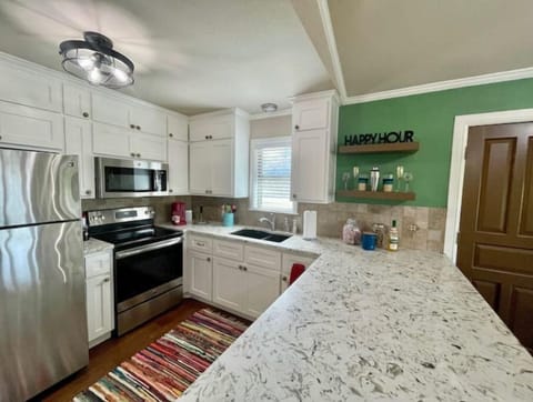 Modern kitchen with white cabinets and granite counters.