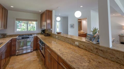 Prepare meals in a modern kitchen featuring granite countertops, stainless steel appliances, and warm wooden cabinetry.