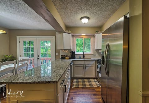 The kitchen has been completely updated, including granite countertops, a workstation sink, and stainless steel appliances (including a dishwasher not shown). The kitchen comes fully stocked with pots and pans, cooking utensils, silverware, etc.