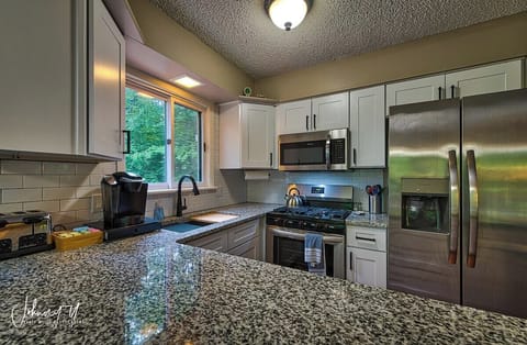 The kitchen has been completely updated, including granite countertops, a workstation sink, and stainless steel appliances (including a dishwasher not shown). The kitchen comes fully stocked with pots and pans, cooking utensils, silverware, etc.