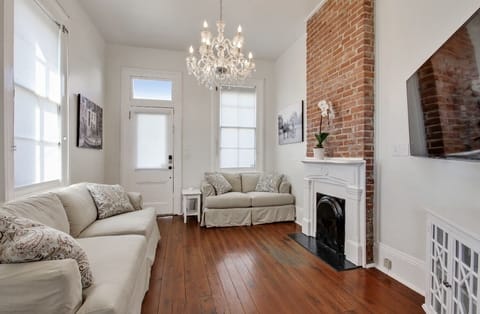 Cozy living room with sofas, vintage brick and a flat screen TV. Bright light.