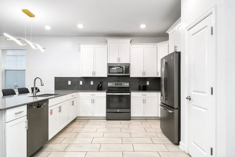 Modern kitchen with sleek stainless steel appliances, white cabinetry, and stylish design.