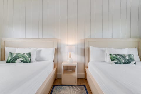 Drift off beside matching beds styled with tropical accents.