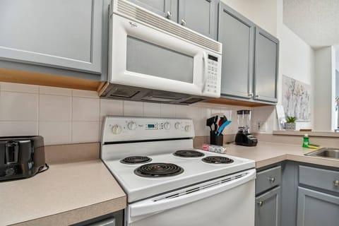 This modern kitchen boasts sleek gray cabinetry and light countertops, creating a clean and functional space. With bright natural light and updated appliances, it’s ideal for preparing meals and enjoying time with guests.