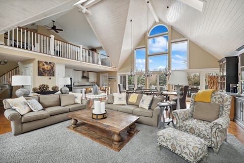 Experience the elegance of this large living room, featuring a magnificent vaulted ceiling and ample natural light. The Christmas candle brings a serene glow, perfect for celebrating the season with loved ones.
