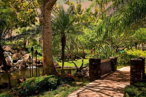 Wander through tropical gardens beside calming water features.