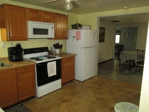 Kitchen stove and refridge, looking into dining room area