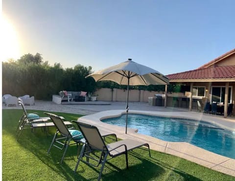 Large yard with pool, lounge furniture, fire pit, bar and dining, bbq, & tv
