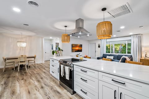Modern coastal open kitchen with stainless steel appliances and disposal.
