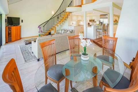 Glass-top dining table offering comfortable seating for upscale group dinners.