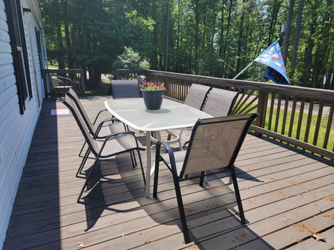 Large front porch with dining for six, reading  a book or playing cards.