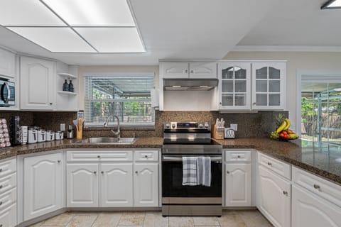 From the rich, warm tones of the cabinets to the gleaming stainless steel finishes, this kitchen is both stylish and functional.