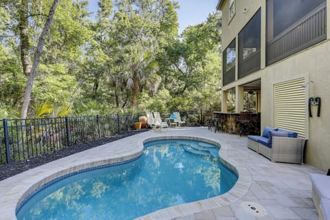 Private pool with outdoor seating, bar with 5 barstools, a gas grill, and a outdoor shower.