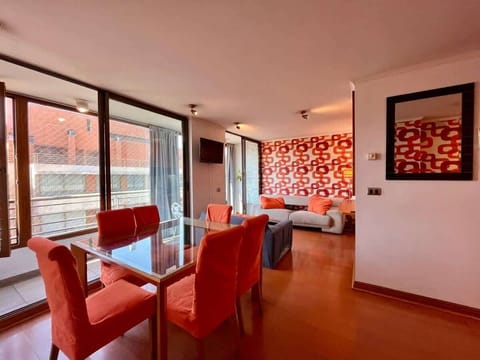 Modern dining area w/ red chairs & large windows bringing in natural light.
